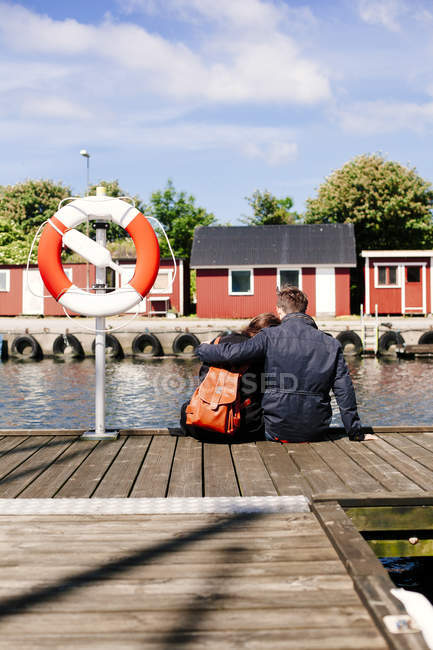 Couple sitting on pier — Stock Photo