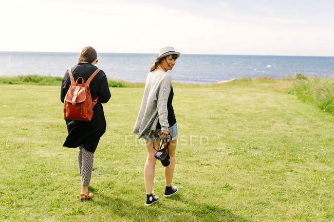 Amici che camminano sulla costa — Foto stock