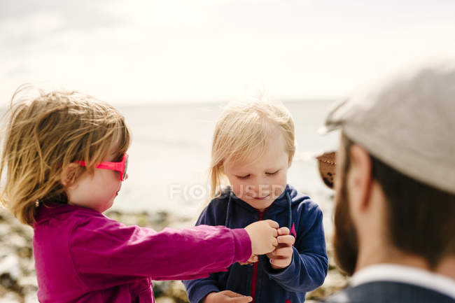 Padre con hijas en la playa - foto de stock