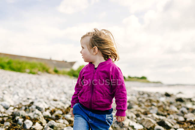 Chica de pie en la playa - foto de stock