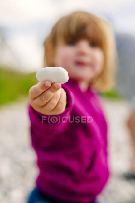 Girl holding pebble — Stock Photo