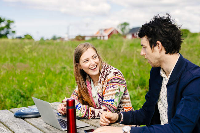 Freunde mit Laptop am Tisch — Stockfoto