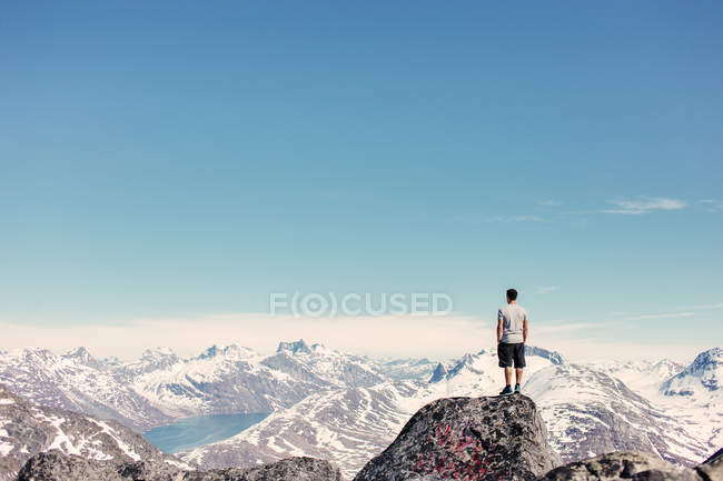 Hombre de pie en la cima de la montaña - foto de stock