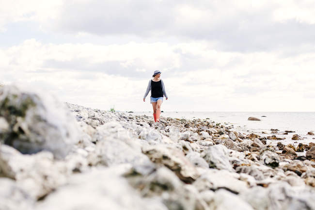 Young woman walking on beach — Stock Photo