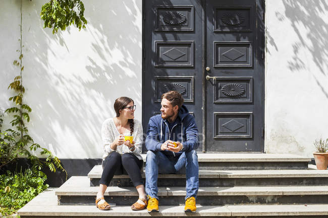 Young couple sitting on steps — Stock Photo