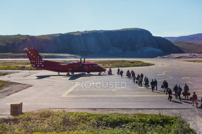 Pessoas caminhando em direção ao avião — Fotografia de Stock