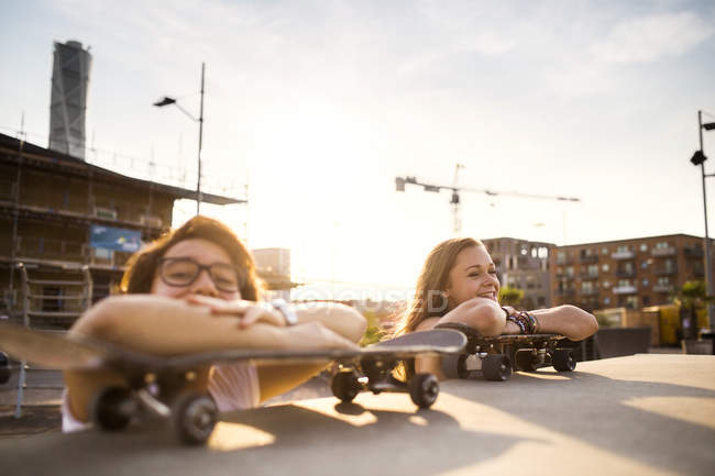 Teenage girls relaxing on skateboards — Stock Photo