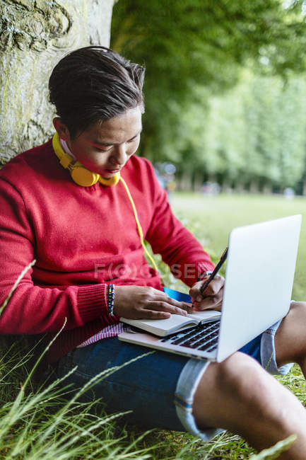 Man writing notes and holding laptop — Stock Photo