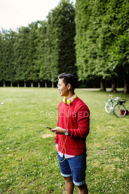 Молодий чоловік тримає мобільний телефон — стокове фото