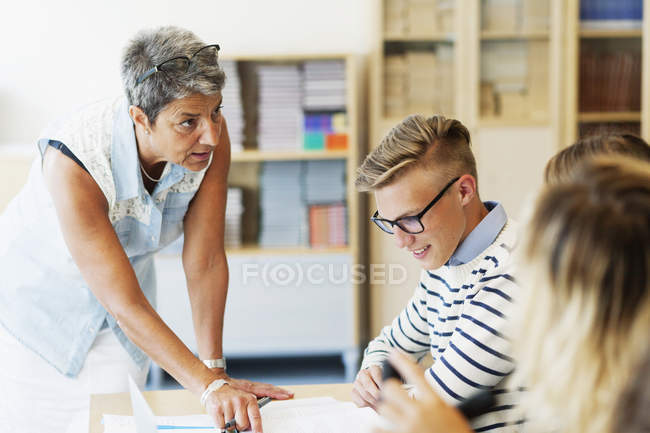 Mature teacher explaining students — Stock Photo