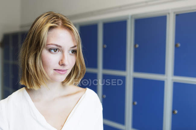 Молода жінка стоїть біля шафки — стокове фото