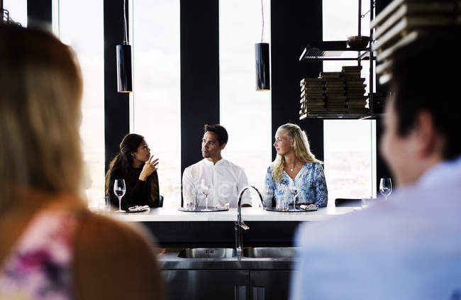 Man with female friends having conversation — Stock Photo