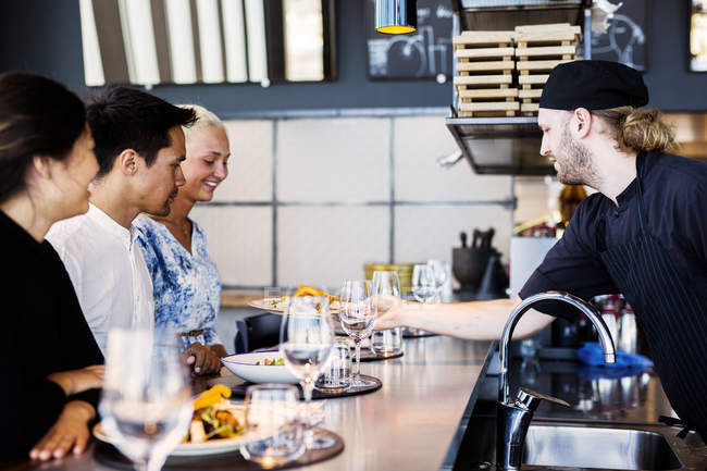 Chef serving meal to customers — Stock Photo