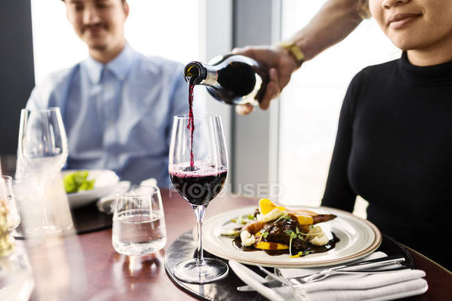Cameriere che serve vino rosso — Foto stock