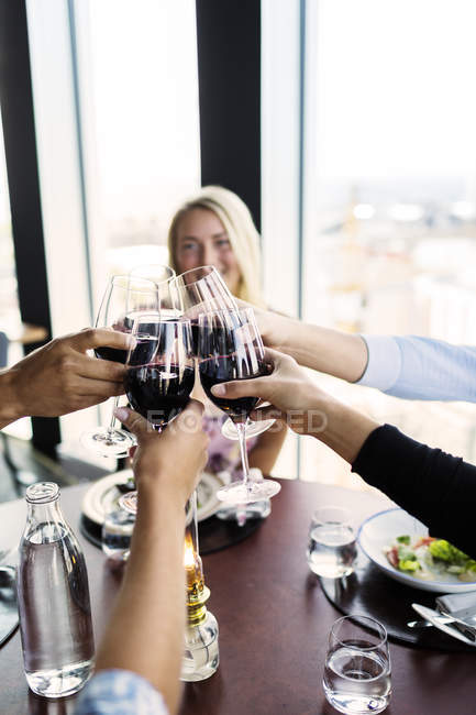 Freunde stoßen mit Rotwein an — Stockfoto
