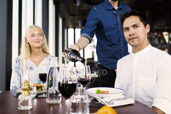Waiter serving red wine — Stock Photo
