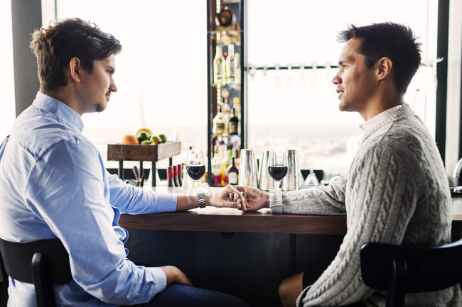 Jovem gay casal sentado no bar — Fotografia de Stock