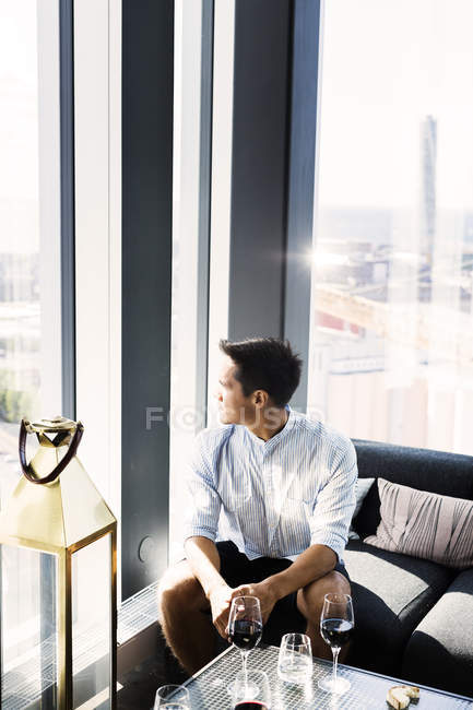 Young man looking through window — Stock Photo