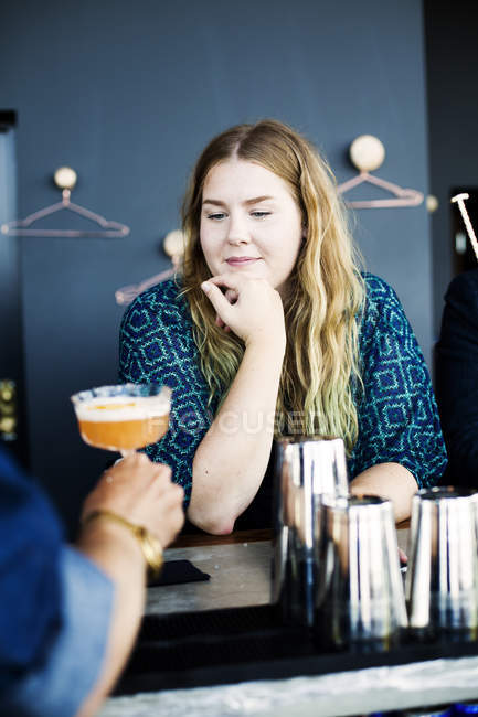Bartender serving glass of cocktail to woman — Stock Photo