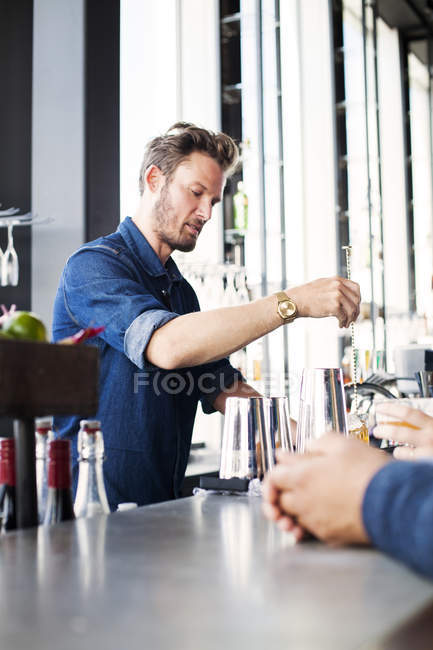 Bartender stirring whisky in glass — Stock Photo