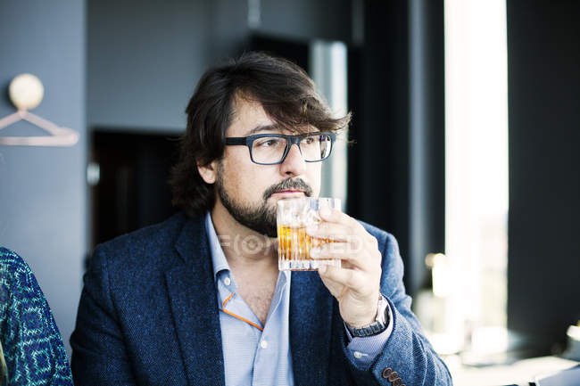 Hombre bebiendo whisky en el restaurante - foto de stock