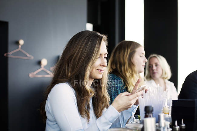 Mulher usando telefone celular no restaurante — Fotografia de Stock