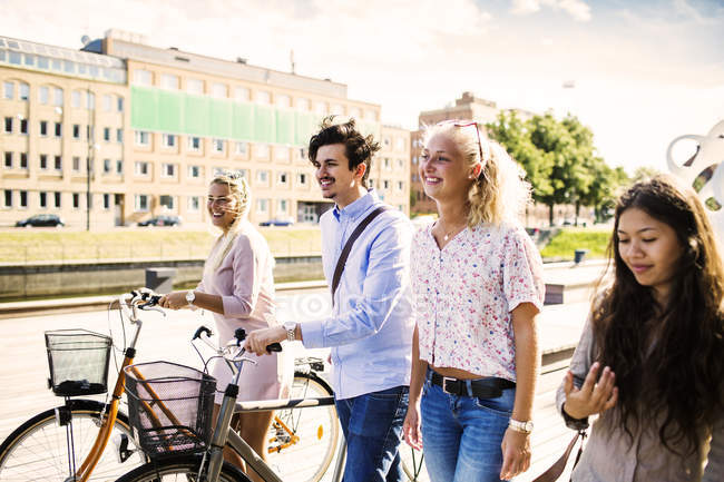 Young friends with bicycles walking — Stock Photo