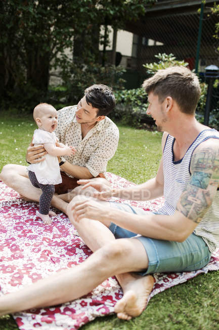 Homosexuell paar spielend mit baby mädchen — Stockfoto