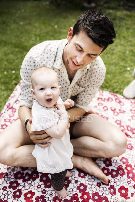 Young man holding baby girl — Stock Photo