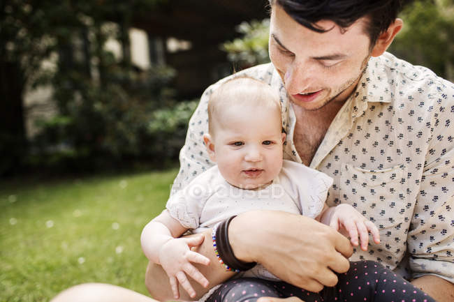 Jeune homme tenant bébé fille — Photo de stock
