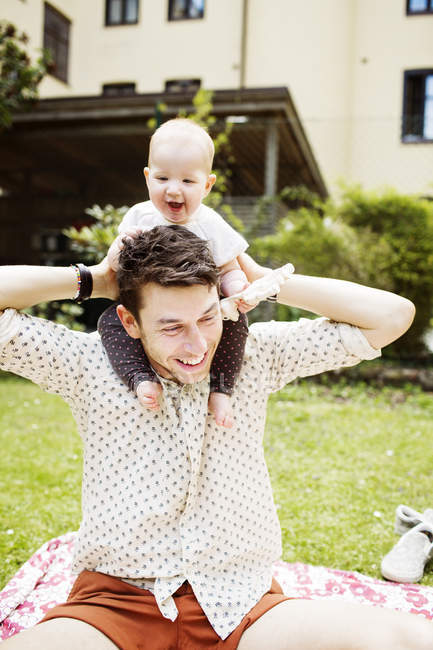 Père portant bébé fille sur les épaules — Photo de stock