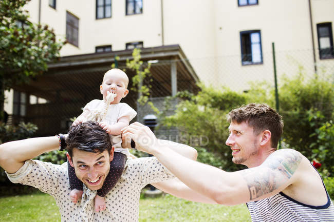 Couple gay jouer avec bébé fille — Photo de stock