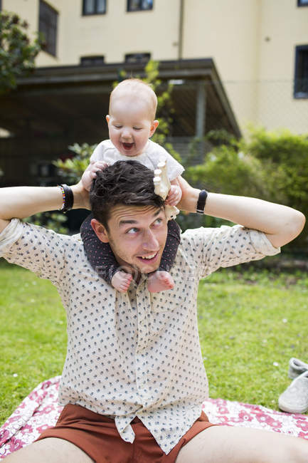Father carrying baby girl on shoulders — Stock Photo