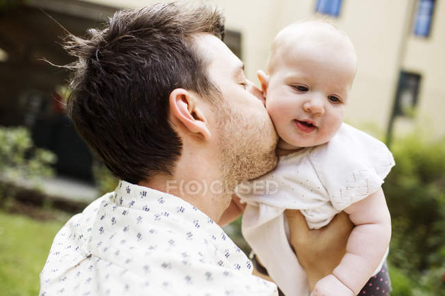 Padre besando bebé niña - foto de stock