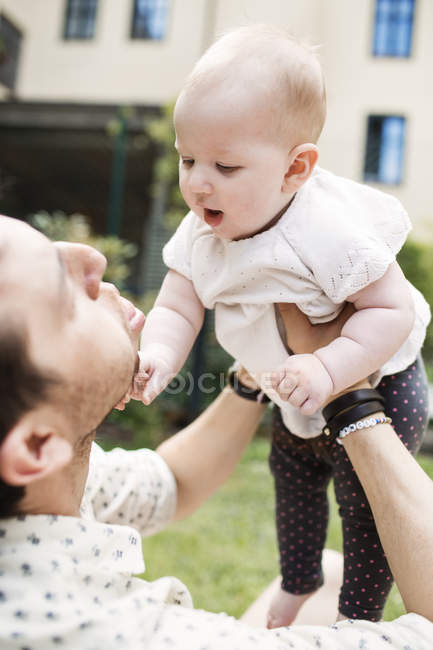 Jovem pai carregando bebê menina — Fotografia de Stock