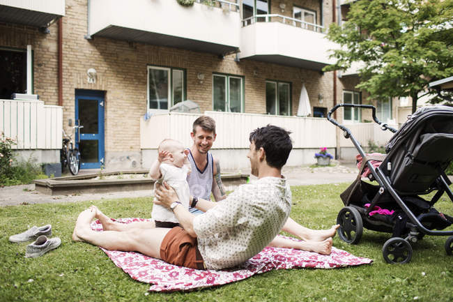 Gay couple playing with baby girl — Stock Photo