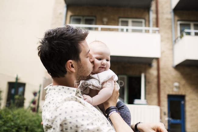 Padre besando bebé niña - foto de stock