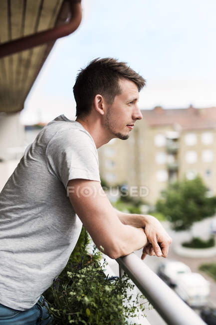 Портрет человека, опирающегося на балкон — стоковое фото