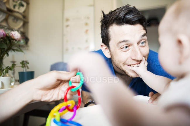Men playing with baby girl — Stock Photo