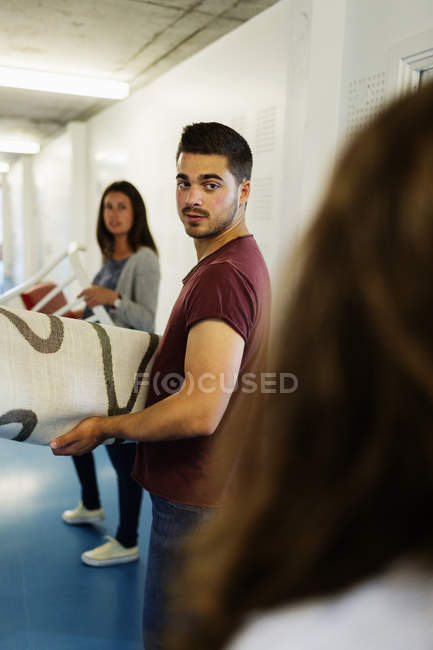 Young friends moving furniture — Stock Photo
