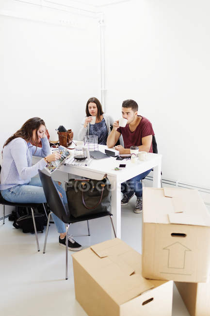 Friends drinking coffee in new home — Stock Photo