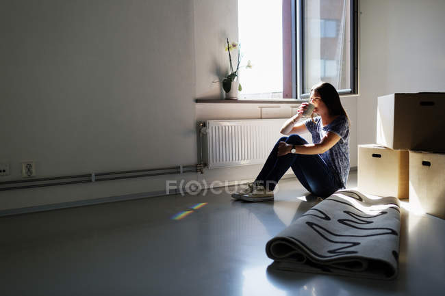 Mulher tomando café na casa nova — Fotografia de Stock