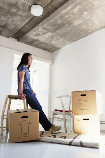 Женщина в новом доме возле коробок — стоковое фото