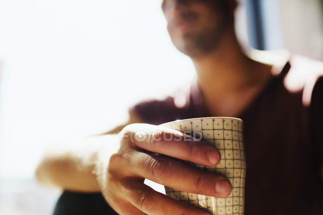 Young man holding coffee cup — Stock Photo