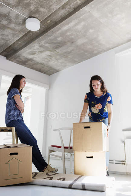 Mulher olhando para caixas de movimento amigo — Fotografia de Stock
