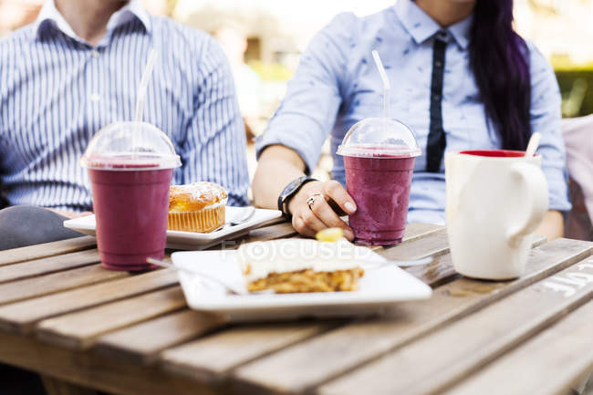 Couple having cakes and smoothies — Stock Photo