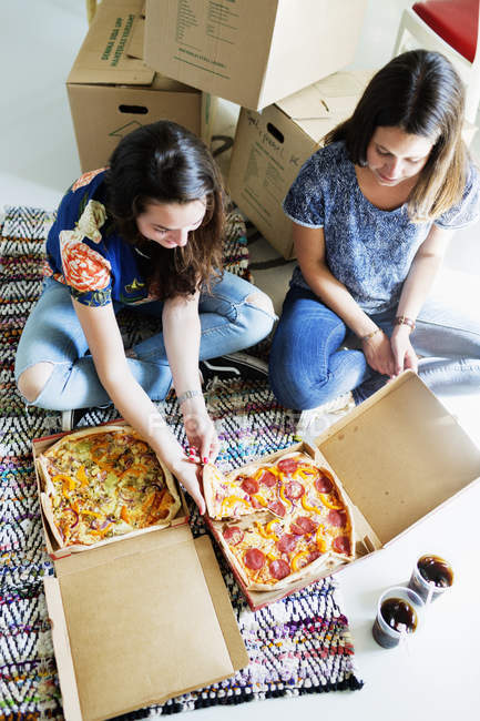 Amigos comendo pizza em nova casa — Fotografia de Stock