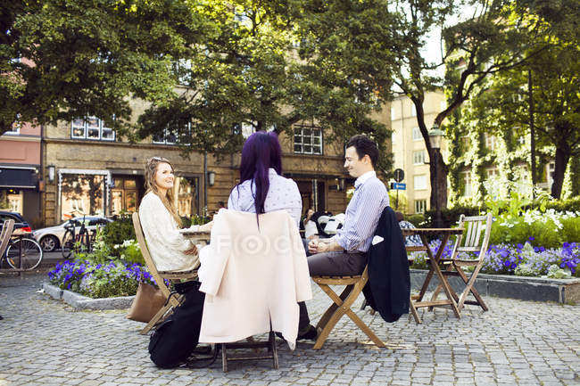 Women and man sitting at cafe — Stock Photo
