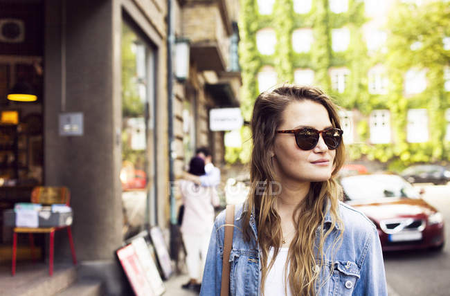 Jeune femme debout dans la rue — Photo de stock