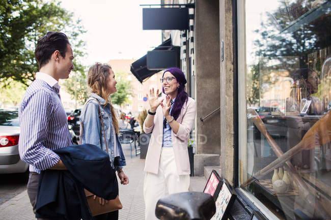 Friends talking outside shop — Stock Photo
